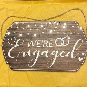 Wooden “We’re Engaged” sign for engagement photos